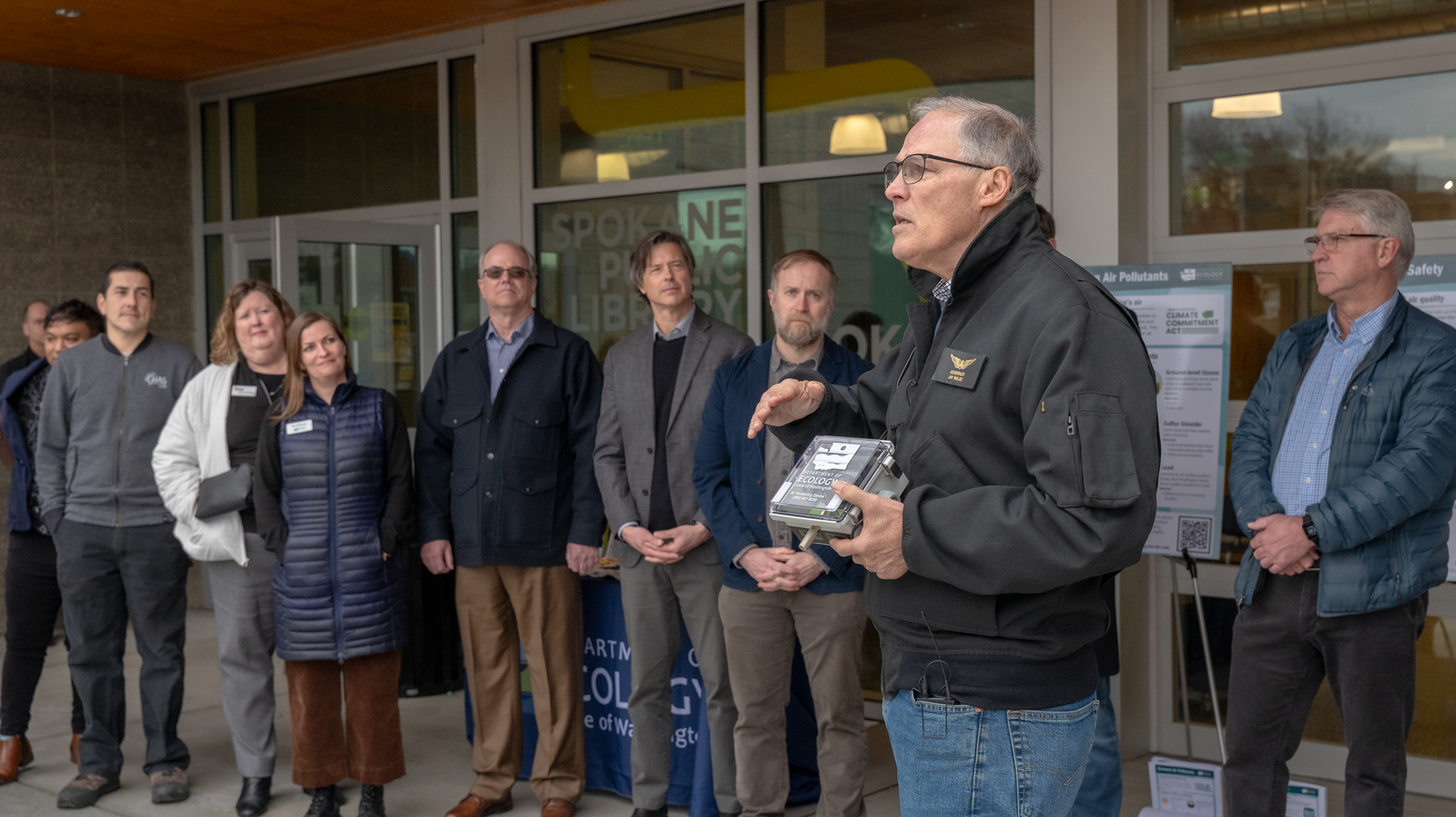 Gov.  Inslee holds a SenseWA monitor while discussing the benefits of the Climate Commitment Act.