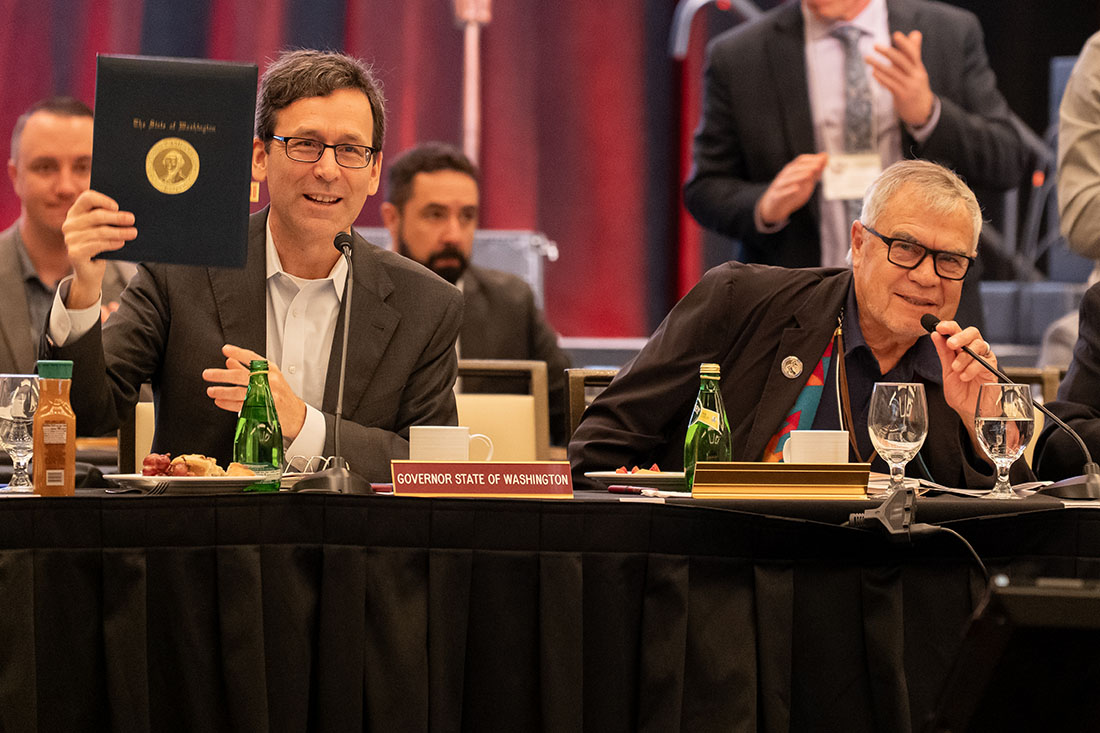 Governor Bob Ferguson holds up his signed executive order as Cowlitz Indian Tribe Chairman William (Bill) Iyall looks on.