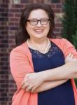Headshot of Jessica Todorovich wearing glasses, blue shirt, and coral sweater.