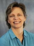 Photo of smiling Julie Meredith, a woman wearing a teal green button-up shirt