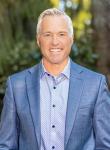 Photo of Dennis Worsham in an outdoor setting wearing a blue blazer and light blue button up shirt
