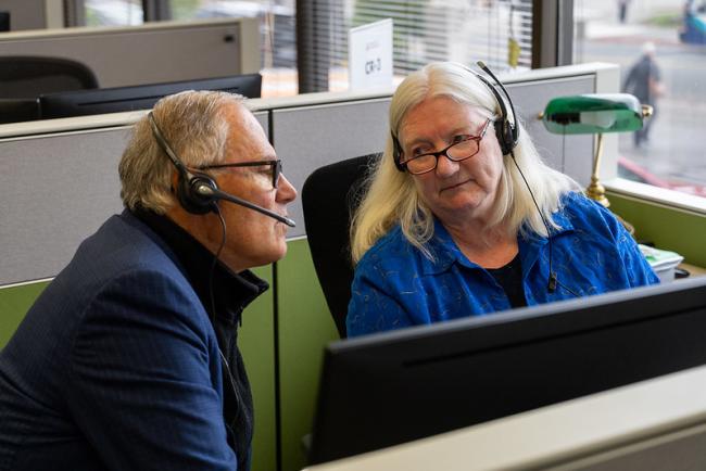 The governor listens to a call at the WA Poison Center with a pharmacist.