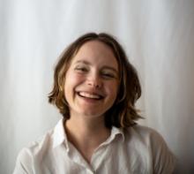 Smiling photo of Kate wearing a white button-up shirt