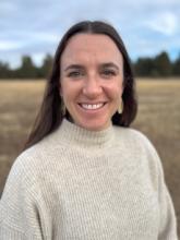 Photo of Mary, in nature, wearing a white sweater